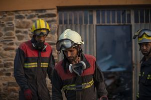 Des pompiers devant une maison brûlée à Rubia (Galice) en Espagne, mardi 19 juillet. Les températures ont atteint jusqu’à 45°C lors de la canicule, provoquant la mort de près de 500 personnes.