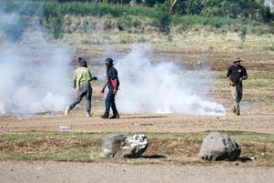 Des manifestants pro-indépendance au milieu de la fumée des gaz lacrymogènes alors que des affrontements ont lieu avec des gendarmes lors de l’enlèvement d’un barrage routier à Dumbéa, le 24 juin 2024.