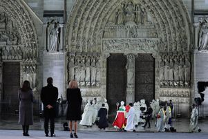 Emmanuel et Brigitte Macron, ainsi que la maire de Paris Anne Hidalgo, devant Notre-Dame au moment où Mgr Ulrich rouvre les portes de la cathédrale. 