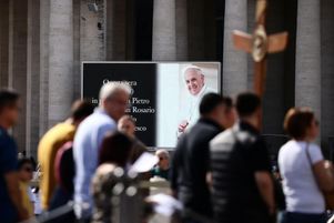 Un écran sur la place Saint-Pierre affiche une annonce de rosaire pour le pape François, après l’annonce de la mort du pontife par le Vatican, vue de Rome, Italie, le 21 avril 2025.