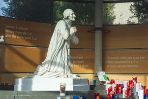 Sanctuaire d’Ars dédié à Saint Jean-Marie Vianney, patron de tous les prêtres de l’univers, statue du Curé d’Ars dans la lanterne de bougies.